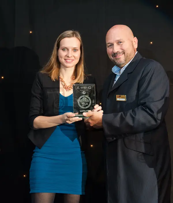 Woman in a blue dress receiving a glass award at the 2014 bis Awards at The Savoy