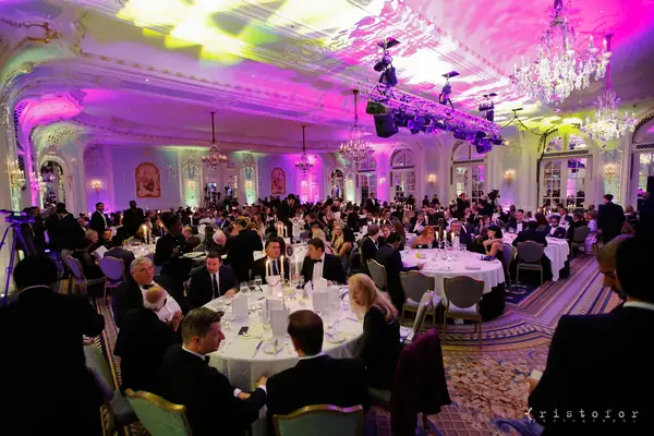 The ballroom of The Savoy lit pink and purple, full of guests at dinner for the 2014 bis Awards