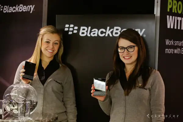 Two women showing phones on the BlackBerry stand at the British Invention Show 2014