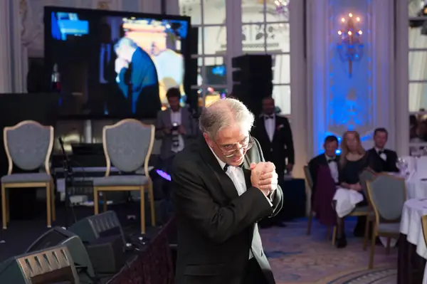 Guest speaking into a microphone in the ballroom at the 2014 bis Awards at The Savoy