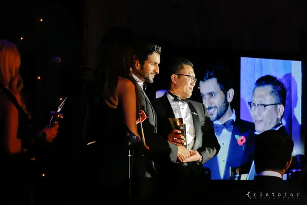 Award winners in black tie on stage in front of a large screen at the 2014 bis Awards at The Savoy