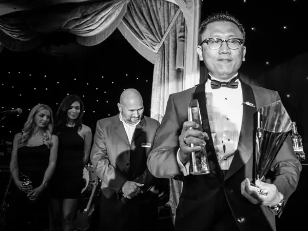 Award winners walking on stage at a bis awards evening, in black and white