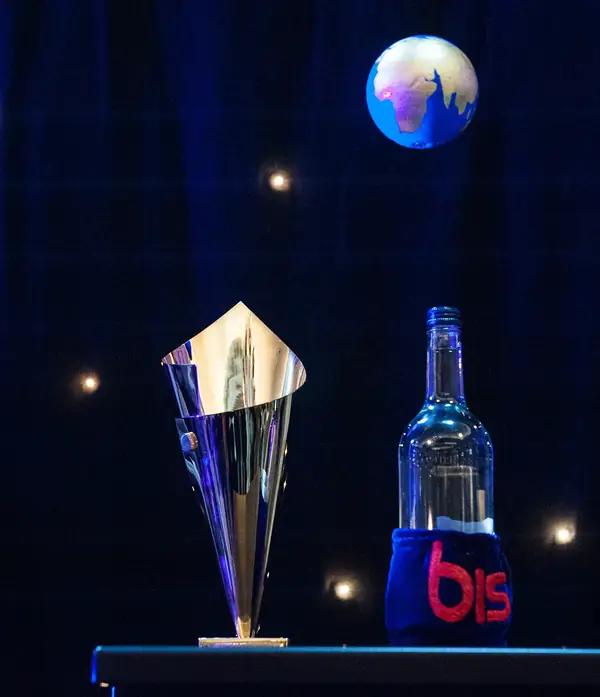 Gold trophy cup and a bis bottle on stage beneath a glowing globe at the 2014 bis Awards at The Savoy
