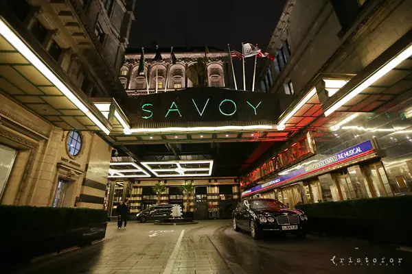 The entrance of The Savoy hotel on the Strand, London, at night