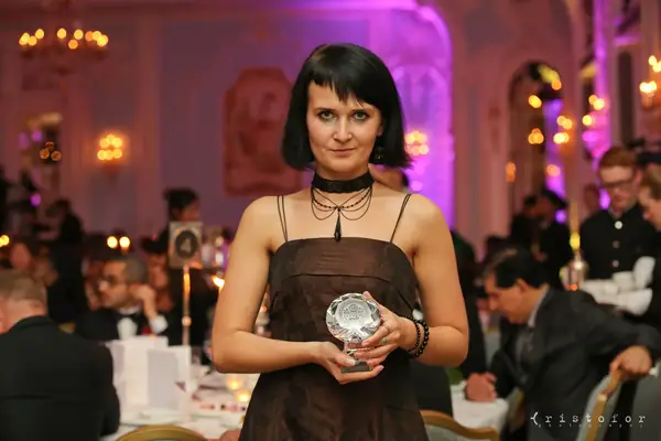 Guest holding a crystal award in the ballroom at the 2014 bis Awards at The Savoy