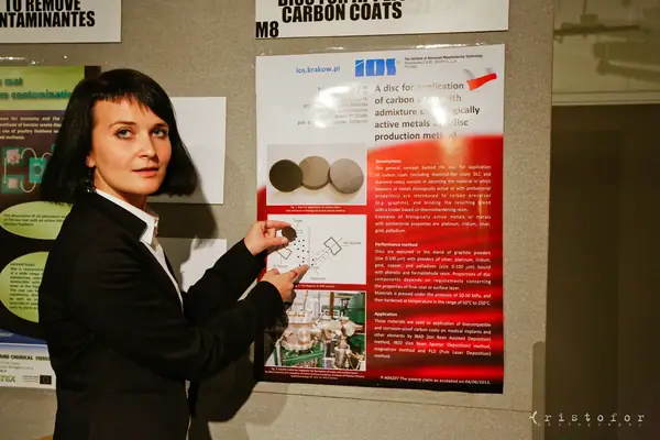 Inventor beside her poster on carbon coats with biologically active metals, from the Institute of Advanced Manufacturing Technology, Kraków