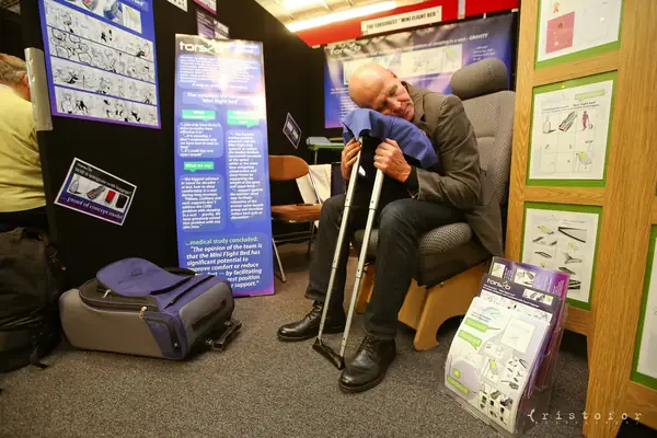 Visitor seated with a pair of crutches on an exhibitor stand at the British Invention Show 2014