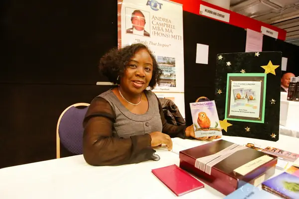 Exhibitor seated at her stand with a display of books at the British Invention Show 2014