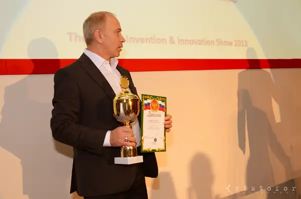 Winner holding a gold cup and certificate at the British Invention Awards 2013