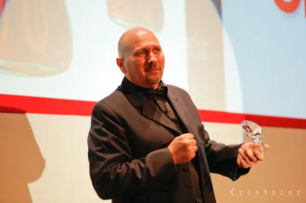 Presenter on stage holding a crystal award at the British Invention Awards 2013